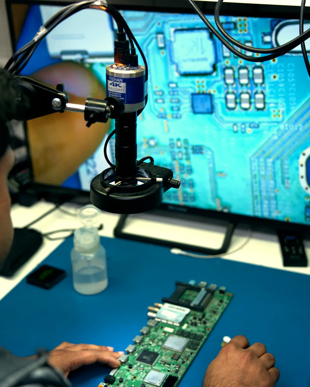 Reparación de una placa con el microscopio del taller